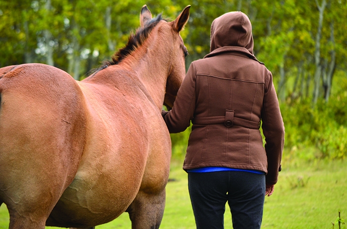 Karyn, a '60s Scoop and residential school survivor, enjoys riding and walking alongside her gentle horse, a horse that continues, she says, to bring healing and comfort to her.